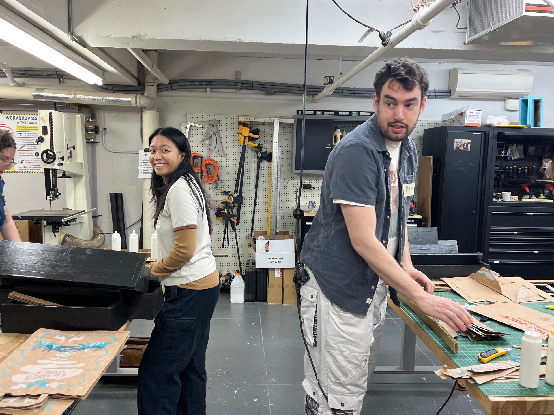 Two Hearth volunteers working side by side in a workshop on a service project.